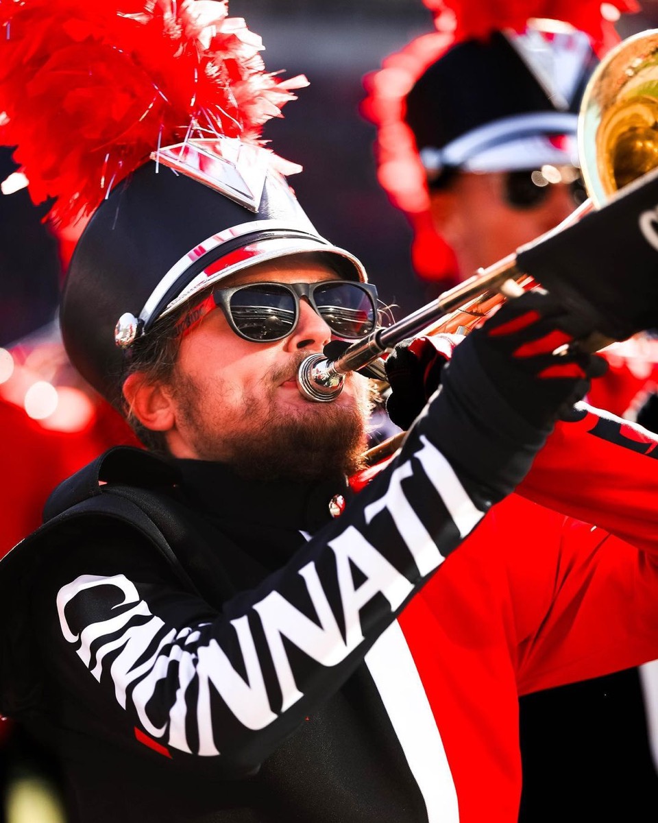 Levi Huff playing trombone in University of Cincinnati Bearcat Marching Band uniform with sunglasses