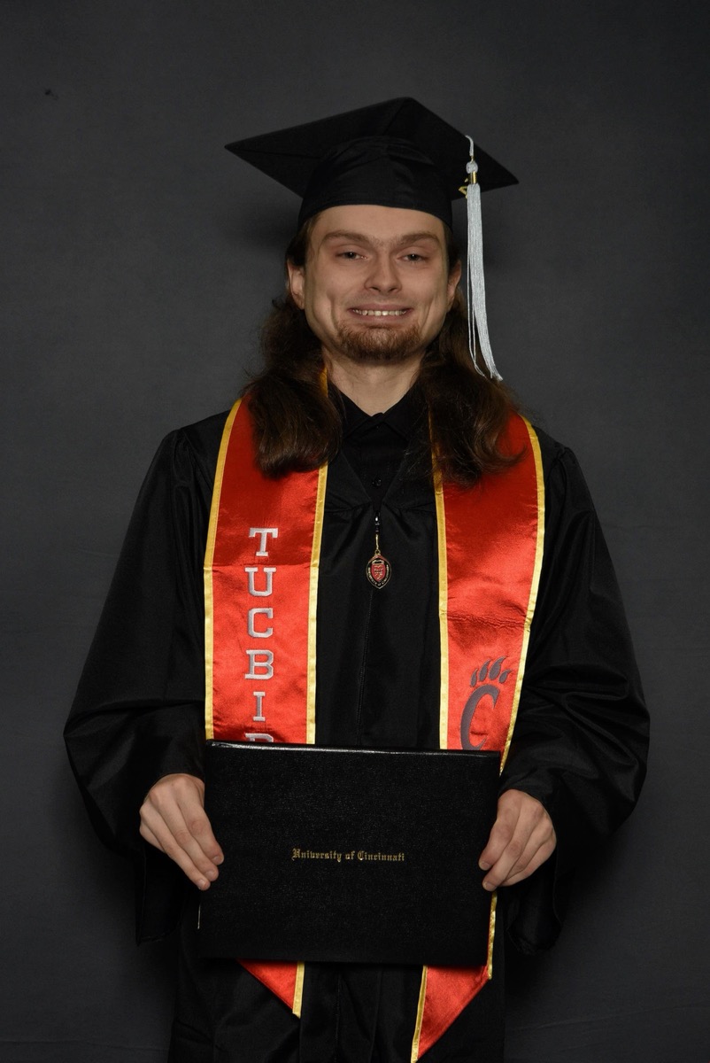 Levi Huff in University of Cincinnati cap and gown holding diploma